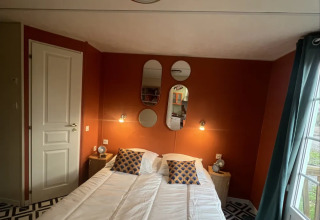 Premium Mobile Home soveværelse på Camping Les Franquettes i Frankrig, med moderne indretning og spejle.