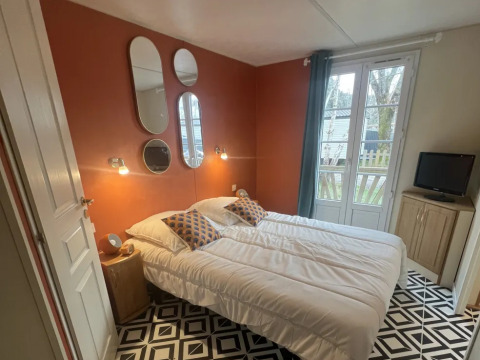 Premium Mobile Home soveværelse på Campsite Les Franquettes i Frankrig med dobbeltseng og moderne indretning.