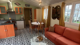 Interiør af Premium Mobile Home Spa med moderne køkken, orange sofa, geometrisk gulv og runde spejle.