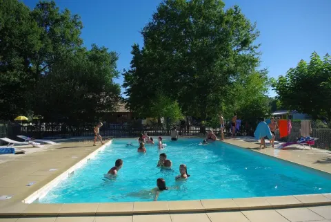 Udendørs swimmingpool ved Premium Mobile Home, Camping Les Franquettes, Frankrig med gæster i vandet.