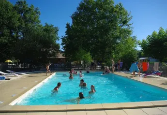 Piscina exterior en Premium Mobile Home, Camping Les Franquettes, Francia, con huéspedes en el agua.