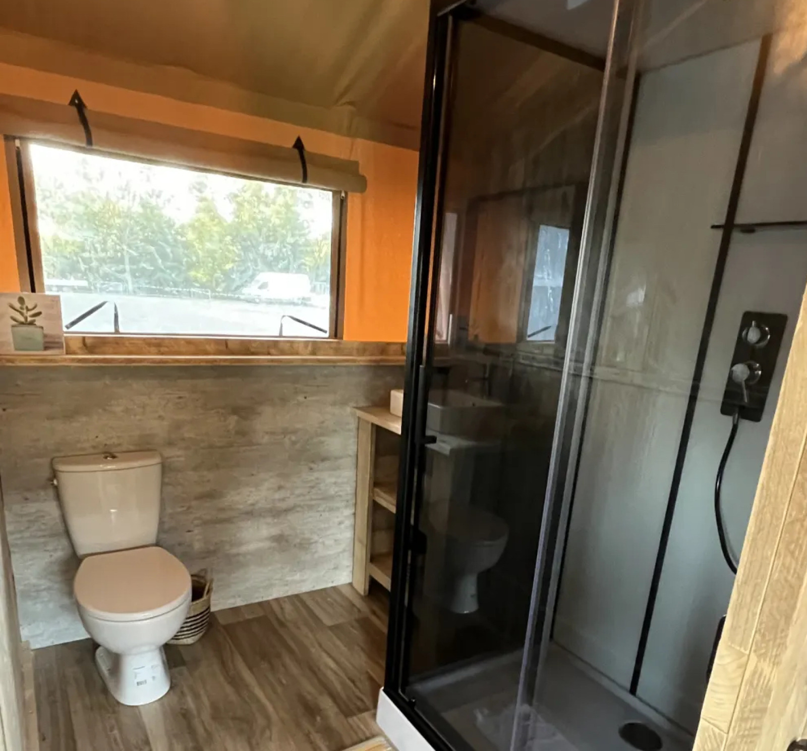 Badkamer in safari tent Lodge Woody 38 op Camping Les Franquettes, met toilet en moderne douche.