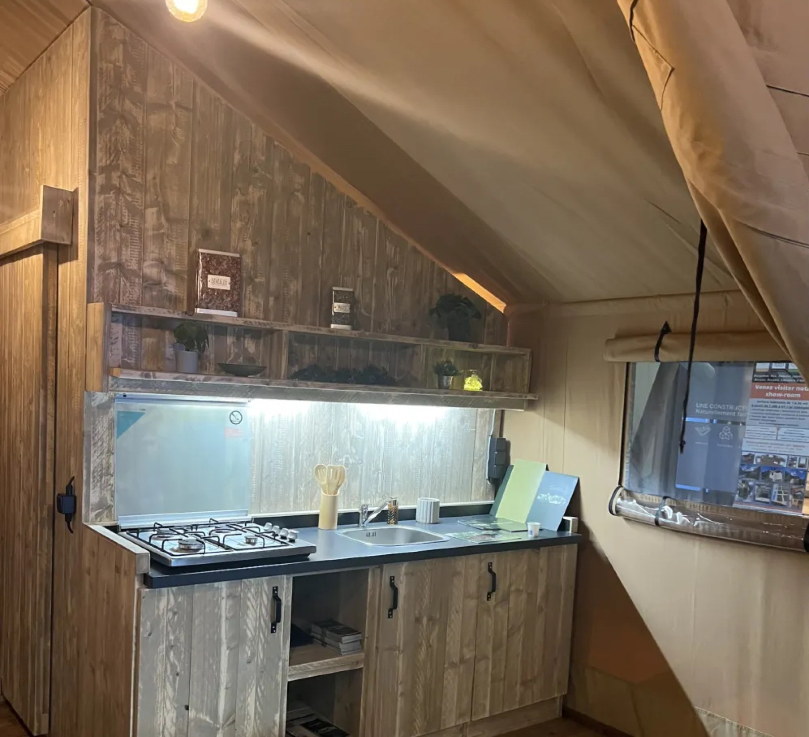 Binnenaanzicht van safaritent Lodge «Woody 38» met rustieke keuken op Camping Les Franquettes.