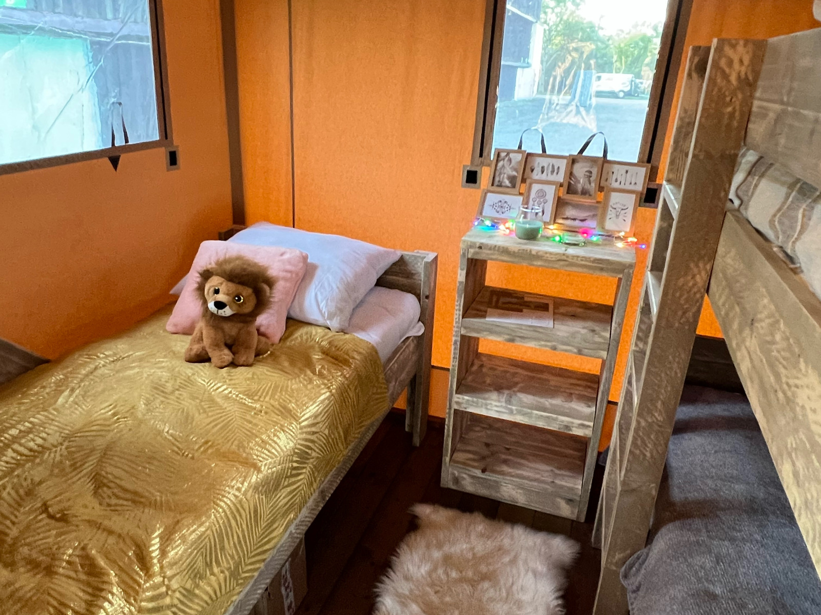 Interieur van safaritent Luxury Lodge 40 op Camping Les Franquettes met bed, stapelbed en decoratie.