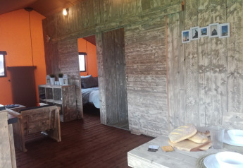 Interno del Luxury Lodge 40, una tenda safari al campeggio Les Franquettes in Francia, con arredi rustici.