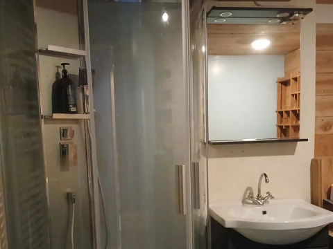 Bagno moderno all'Emperor Bell Tent, Campsite Junora in Francia, con doccia, lavabo e specchio.
