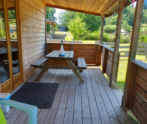Terrazza in legno con tavolo da picnic al 'Self-sufficient, luxury eco-chalet' al Campeggio Junora in Francia.