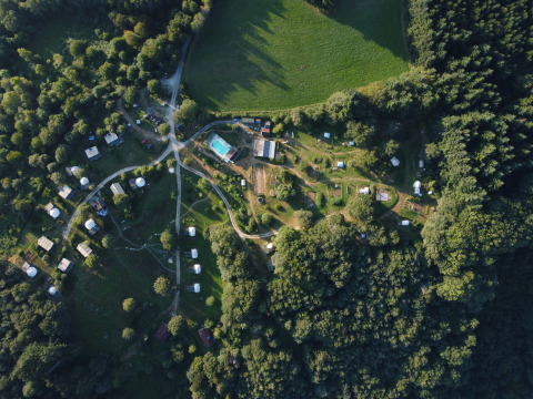 Luchtfoto van camping Junora in Frankrijk met lodge Avignon en tenten tussen bomen en grasvelden.
