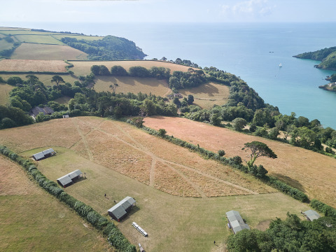 Vista aérea del parque vacacional BoerenBed Fountain Violet Farm junto a la costa en el suroeste de Inglaterra, Reino Unido.