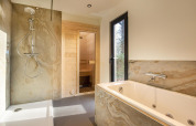 Salle de bain moderne avec douche, baignoire, sauna et fenêtre au Forest Cottage, Holiday Park BreeBronne.