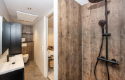 Bagno moderno presso Forest Cube, Holiday Park BreeBronne, Paesi Bassi, con pareti in legno e doccia nera.