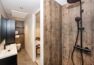 Baño moderno en Forest Cube, Holiday Park BreeBronne, Países Bajos, con paredes de madera y ducha negra.
