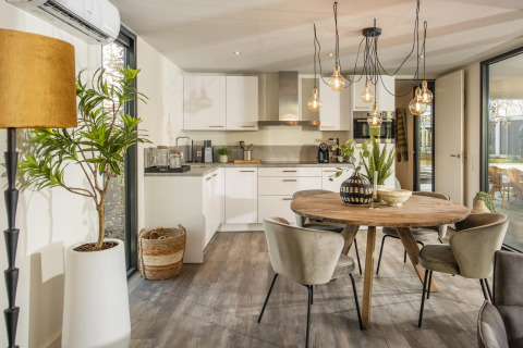 Modern lodge kitchen and dining area at Forest Cube in Holiday Park BreeBronne, Netherlands, bright decor.