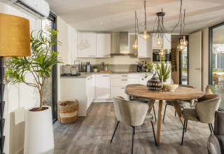 Modern lodge kitchen and dining area at Forest Cube in Holiday Park BreeBronne, Netherlands, bright decor.