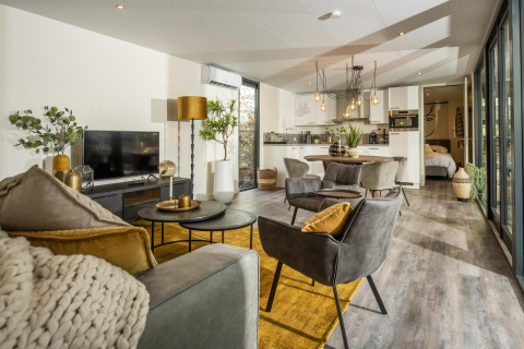 Modern living and kitchen area in the Forest Cube lodge at Holiday Park BreeBronne, Netherlands, stylish decor.