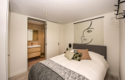 Chambre moderne à la Forest Cube lodge avec décoration murale artistique et vue sur la salle de bain.
