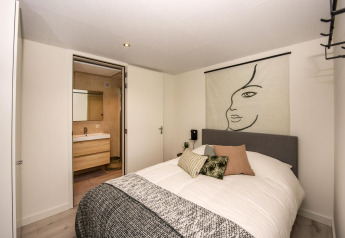 Chambre moderne à la Forest Cube lodge avec décoration murale artistique et vue sur la salle de bain.