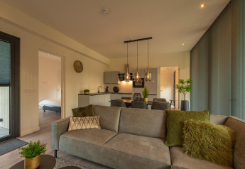 Moderne woonkamer en keuken in Forest Lodge op Holiday Park BreeBronne, Nederland, stijlvol en gezellig.