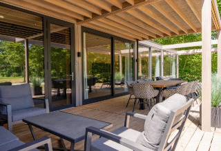 Terraza exterior con muebles modernos en Forest Villa, Holiday Park BreeBronne, Países Bajos, rodeada de naturaleza.
