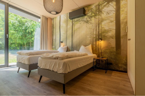 Habitación de lodge con dos camas individuales y papel tapiz de bosque en Forest Villa, BreeBronne, Países Bajos.
