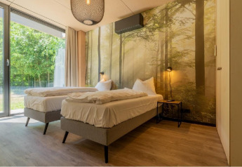 Chambre de lodge moderne avec deux lits simples et papier peint forêt à Forest Villa, BreeBronne, Pays-Bas.