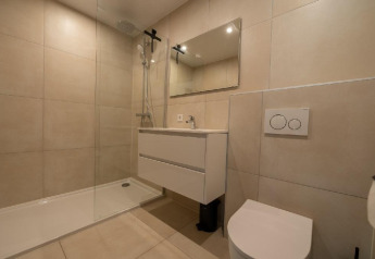 Salle de bains moderne à Forest Villa au Holiday Park BreeBronne avec douche, lavabo et toilettes.