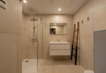 Salle de bains moderne avec douche, miroir et lavabo à Forest Villa du Holiday Park BreeBronne, Pays-Bas.