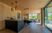 Lodge Forest Villa moderne au Holiday Park BreeBronne, Pays-Bas, avec salon lumineux et grandes baies vitrées.