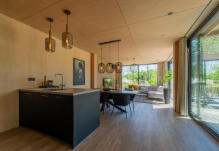 Lodge Forest Villa moderne au Holiday Park BreeBronne, Pays-Bas, avec salon lumineux et grandes baies vitrées.