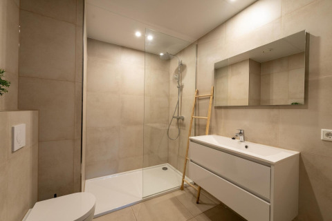 Bagno moderno con doccia in vetro, scala di legno e mobile bianco a Forest Villa, Holiday Park BreeBronne.