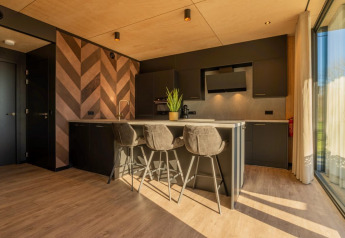Cucina moderna nella Forest Villa al Holiday Park BreeBronne, Paesi Bassi, con parete effetto legno.
