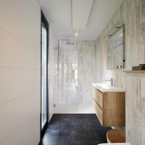 Moderne badkamer in Water Cube lodge met houten wastafel, glazen douche en groot raam voor licht.