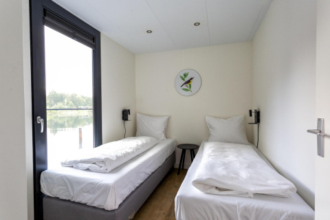 Lichte kamer in Water Cube, Holiday Park BreeBronne, Nederland, met twee bedden en uitzicht op het meer.