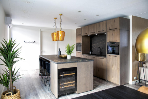 Moderne keuken in de Water Cube-lodge van Holiday Park BreeBronne, Nederland, met houtafwerking.