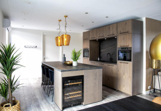 Moderne keuken in de Water Cube-lodge van Holiday Park BreeBronne, Nederland, met houtafwerking.