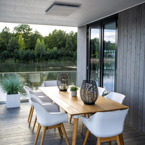 Moderne terras aan het meer bij Water Cube-lodge in Holiday Park BreeBronne, Nederland, met tafel en stoelen.