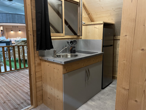 Petite kitchenette avec évier, plaque de cuisson et réfrigérateur dans une tente safari au Chianti Glamping Resort.