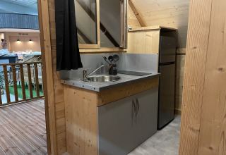 Petite kitchenette avec évier, plaque de cuisson et réfrigérateur dans une tente safari au Chianti Glamping Resort.