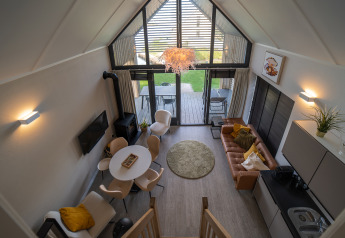 Gemütliches Wohnzimmer in der Villa «Oesterdam» im Oesterdam Resort, mit hellen Fenstern und moderner Einrichtung.