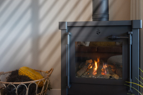 Caminetto moderno con fuoco vivo nella Villa «Oesterdam» all’Oesterdam Resort, Paesi Bassi, con cestino vicino.