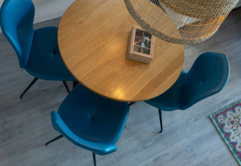 Runder Holztisch mit vier blauen Stühlen, von oben gesehen in der Villa Oesterdam im Oesterdam Resort, Niederlande.