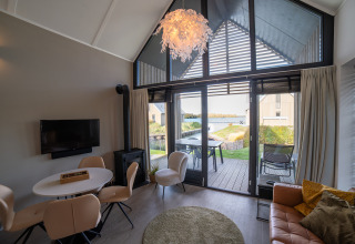 Lodge moderno con ampie finestre, arredamento elegante e vista sul lago presso Villa Oesterdam, Oesterdam Resort, Paesi Bassi.