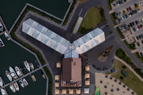 Luftaufnahme der Glamping-Unterkunft Villa Oesterdam mit Gebäuden, Yachthafen und Parkplatz.