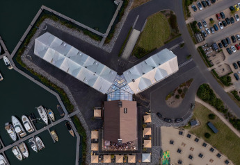 Vista aerea della sistemazione glamping Villa Oesterdam con edifici collegati e marina.