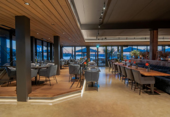 Interno di un ristorante moderno a Villa Oesterdam glamping, con ampie finestre e posti a sedere raffinati.