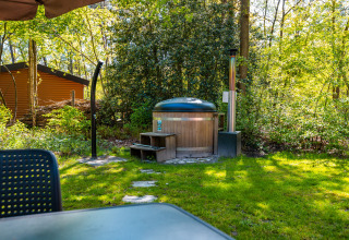 Buitenspa en terras bij lodge Velthorst in vakantiepark De Wiltzangh, omringd door groen in Nederland.