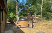 Jacuzzi exterior en Wellness Lodge «Wood XL» en el parque De Wiltzangh, Países Bajos, rodeado de naturaleza.