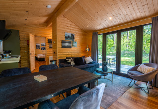 Gemütliches Wohnzimmer in der Wellness Lodge «Wood XL» mit Holzwänden und Ausblick im De Wiltzangh.