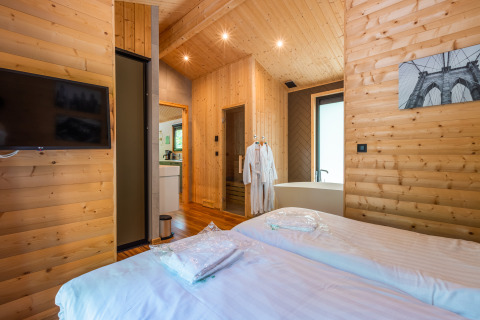 Camera lodge wellness moderna con pareti in legno, letti gemelli e vasca da bagno a De Wiltzangh nei Paesi Bassi.
