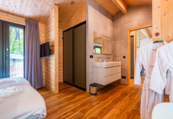 Moderna Wellness Lodge «Wood XL» presso Holiday park De Wiltzangh nei Paesi Bassi con arredo in legno e camera.